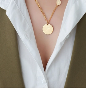 Detail of gold coin necklace with portrait pendant and mismatched paperclip chain links