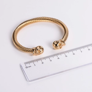 Dettaglio del bracciale rigido a teschio dorato in acciaio con misura delle dimensioni