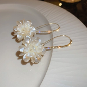 Gros plan de boucles d'oreilles fleurs avec crochets dorés sertis de cristaux brillants