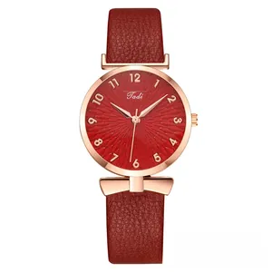 Detail of burgundy leather strap with rose gold bow decoration and sunburst dial watch