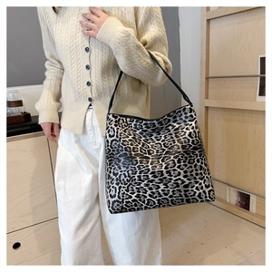Detailed close-up of a stylish leopard print oversized tote bag worn by a model