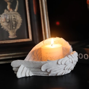 White resin angel wing candle holder with feather texture and classic scented candle