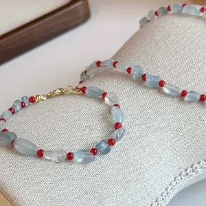 Dettaglio di perline di acquamarina e agata rossa su set di collana e braccialetto
