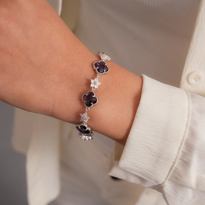 Détail d'un bracelet floral de luxe avec trèfles violets et cristaux étincelants