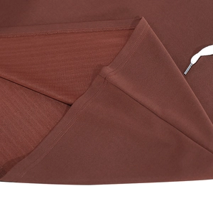 Détail de la maille du polo marron avec coutures précises et cordon blanc à embout métallique