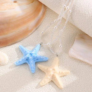 Detail of beaded summer necklaces with blue and cream starfish charms on shells