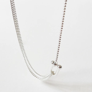 Macro detail of 925 sterling silver U-link pendant necklace with asymmetric chain design
