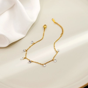 Detail of gold minimalist chain bracelet featuring seven clear circular crystal charms