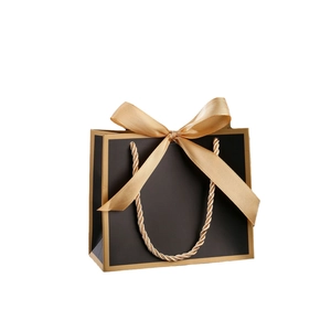 Elegant black gift paper bag with gold border, ribbon bow and twisted rope handles