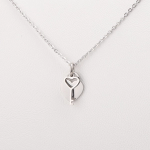 Detailed close-up of silver heart and key pendant on stainless steel necklace chain