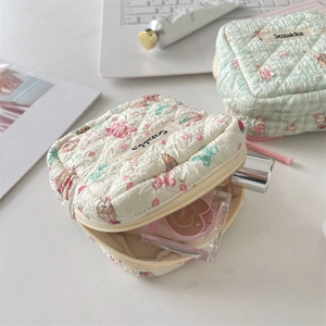 Detailed view of the quilted cartoon sanitary bag showing pink rabbits and inner items