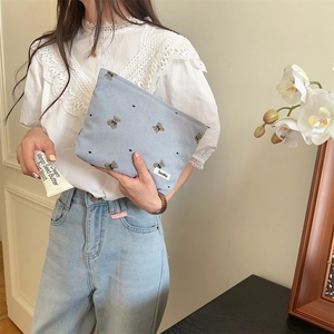 Detail of light blue corduroy pouch with cute bear pattern and Sozakka brand tag