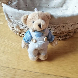 Simpatico portachiavi orsetto di peluche con camicia a quadri blu su legno