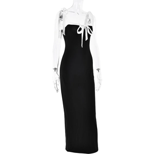 Detail view of black bodycon maxi dress with white shoulder straps and front bow accent