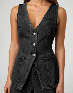 Gros plan d'un gilet en jean gris foncé montrant les boutons et les détails de coupe