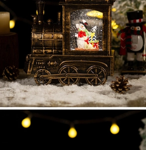 Close-up of bronze Christmas train snow globe with snowman and dog figures in warm holiday light