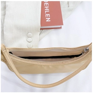 Detail view of the nylon crossbody bag opening with smooth zipper and black lining