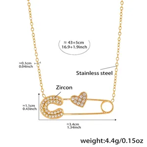 Detailed view of 18k gold plated safety pin necklace with heart and C letter charms