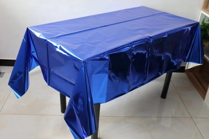 Detail view of glossy dark blue metallic tablecloth with aluminum foil texture on table