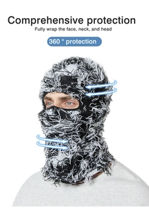 Close-up of knitted balaclava showing frayed fringe edges and distressed black white texture