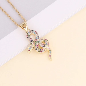 Macro shot of 18K gold snake pendant necklace featuring colorful cubic zirconia stones