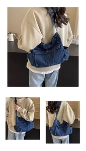 Detail of blue denim tote bag showing functional pockets and adjustable canvas shoulder strap