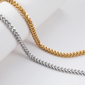 Close-up of gold and silver wheat link chains in stainless steel with polished finish