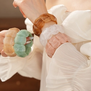 Macro view of geometric faceted resin bangles in varied colors with marble texture