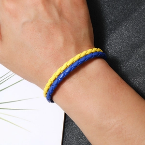 Braided leather bracelet with blue and yellow Ukraine flag colors on a wrist