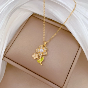 Detailed shot of a floral titanium steel necklace with green enamel leaves and pearls