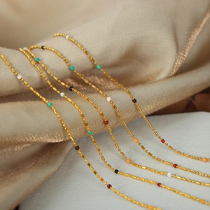 Minimalist gold plated titanium steel chain with multi-color enamel beads on silk background