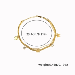 Detail shot of double-layered gold bracelet with butterfly charm and cubic zirconia accents