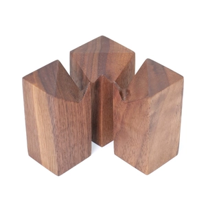 Detailed view of three conical black walnut wooden ring stands with brass accents
