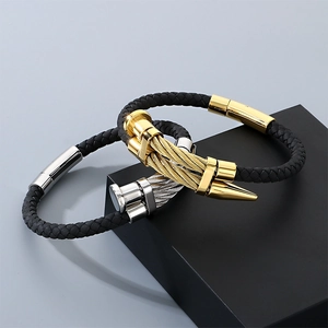 Close-up of gold and silver men's woven bracelets with metallic nail head design