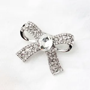 Detailed view of a bow-knot brooch featuring sparkling rhinestones and a large oval crystal