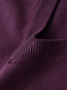 Dettaglio maglione in maglia viola scuro con scollo a costine e trama del tessuto