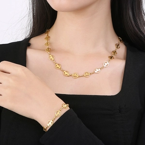 Parure de bijoux en acier titane doré avec pendentifs croix ronds sur collier à maillons