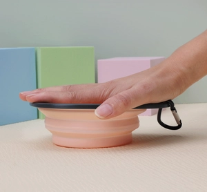 Collapsible silicone pet bowl in pink with carabiner clip for portable outdoor travel