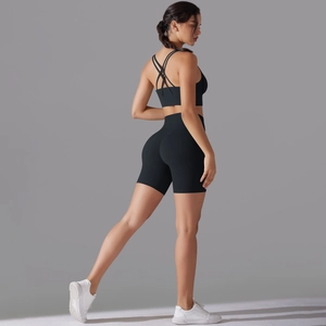 Dettaglio dei pantaloncini fitness neri a vita alta e del reggiseno sportivo incrociato