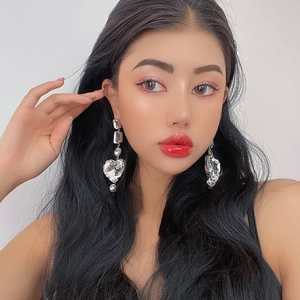 Elegant silver long drop earrings with oversized heart-shaped crystals on model