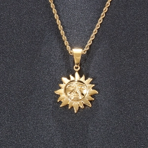 Vue détaillée du pendentif soleil plaqué or vintage avec une chaîne en maille torsadée
