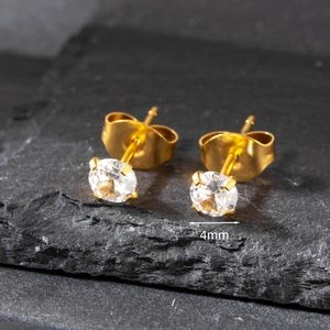 Macro detail of 4mm golden stainless steel stud earrings with round cubic zirconia