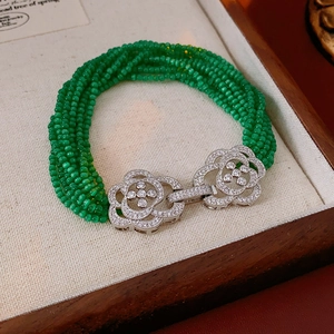 Detail of multi-strand green beaded bracelet with a silver floral crystal clasp