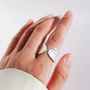Close-up of adjustable silver leaf ring with handmade matte texture on a model hand