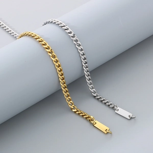 Detail of gold and silver cuboid pendant curb chain bracelets on a grey display stand