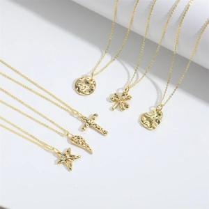 Golden clover heart and cross necklaces with colorful zircon stones on white background