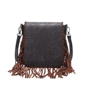 Detail of vintage bohemian crossbody bag with floral embossing and brown leather tassels