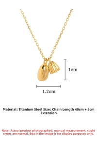 Macro view of gold titanium steel necklace with smooth oval and textured bell pendants