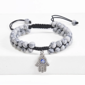 Detail of Hamsa hand bracelet with marble stones and adjustable woven cord strap