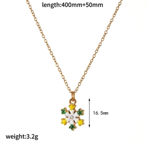 Detailed view of golden snowflake necklace with enamel charm and product dimensions